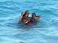 Lucky dude, swimming in the ocean with two juicy tomatoes, whose bikini tops were washed down by playful waves!